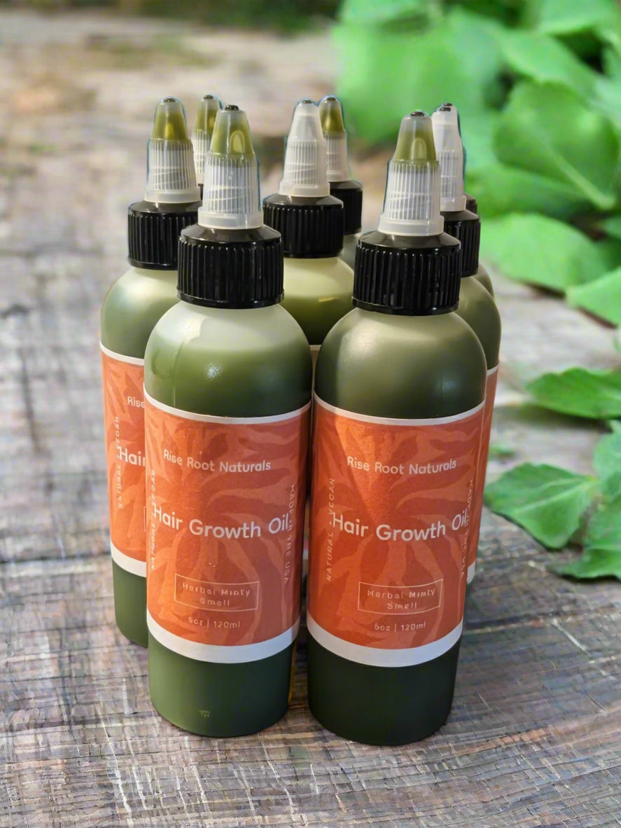 Multiple bottles of Hair Growth Oil on a dark surface with a light background